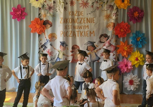 Dzieci prezentują część artystyczną przygotowaną na zakończenie edukacji przedszkolnej. Wydarzenie odbywa się w obecności rodziców oraz pracowników przedszkola.
