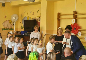 Dzieci oraz zgromadzeni goście uczestniczą w uroczystości, która kończy kolejny etap ich rozwoju i nauki.