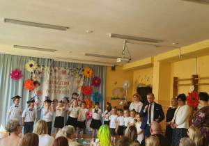 Podczas przemówienia pana dyrektora dzieci słuchają słów wsparcia i gratulacji związanych z ukończeniem przedszkola.