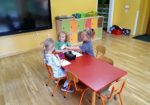 Przedszkolaki rozwijają swoją kreatywność, tworząc kolorowe rysunki przy użyciu kredek.