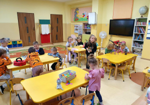 Przedszkolaki wspólnie budują konstrukcję z klocków, rozwijając wyobraźnię i umiejętność współpracy.