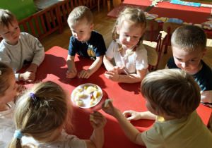 Dzieci próbują różnych odmian jabłek, porównując ich smak i dzieląc się swoimi wrażeniami.