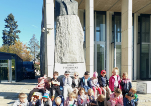 Zatrzymani na chwilę – pamiątkowa fotografia na tle pomnika Józefa Piłsudskiego.