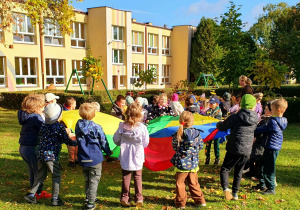 Dzieci wspólnie bawią się na świeżym powietrzu, uczestnicząc w zabawach integracyjnych, które sprzyjają budowaniu relacji i wzajemnej życzliwości.