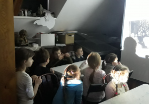 dzieci w sali muzealnej oglądają film