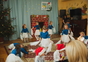 występ przedszkolaków ubranych w niebiesko - białe stoje przed zaproszonymi gośćmi
