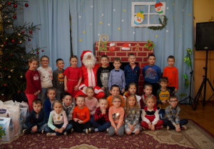 Dzieci z grupy VI pozują do zdjęcia z Mikołajem