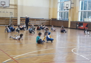 dzieci wykonują ćwiczenia na sali gimnastycznej