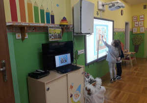 dzieci bawią się przy tablicy multimedialnej