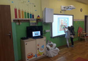 dzieci wykonują zadania na tablicy multimedialnej