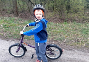 chłopiec w lesie na rowerze