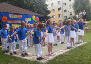dzieci w niebieskich strojach tańczą