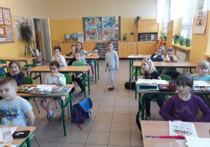dzieci siedza w klasie przy ławkach