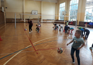 Dzieci odbijają piłki o podłogę