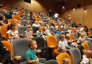 dzieci siedzą w sali kinowej
