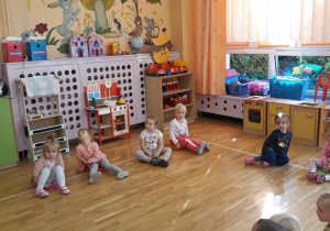 dzieci siedzą na podłodze