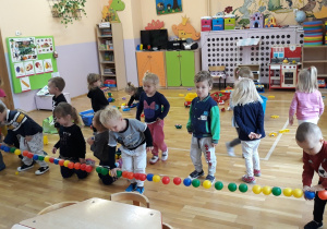dzieci ucza się kolorów, przyklejaja piłki do taśmy
