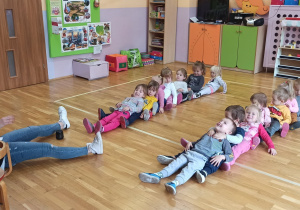 dzieci leżą na podłodze w dwóch rzędach