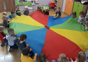 dzieci bawia się kolorową chustą