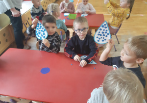dzieci wyklejają niebieską plasteliną krople deszczu