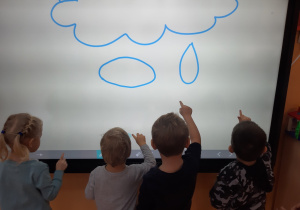 dzieci rysują na tablicy krople deszczu