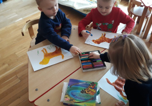 przedszkolaki malują pastelami tło