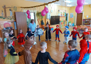 dzieci przebrane w stroje karnawałowe tańczą do wesołej muzyki