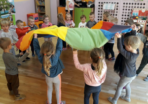 dzieci podnoszą kolorową chustę