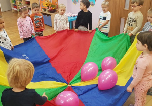 wspólna zabawa przedszkolaków kolorową chustą i balonami
