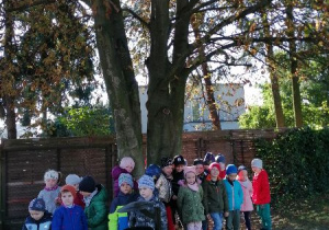dzieci stoją pod drzewem