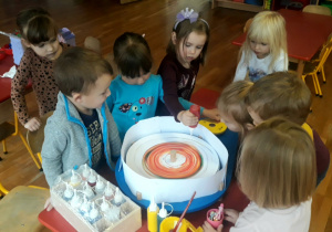 dzieci tworzą tęczowe barwy przy pomocy maszyny