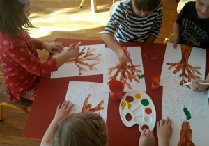 przedszkolaki malują farbami kontur drzewa