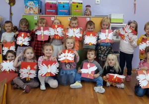 dzieci z grupy III prezentują własnoręcznie wykonane godło Polski