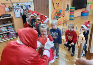 Dzieci odbierają prezent od Mikolaja