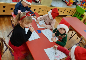 Dzieci kolorują rysunek Mikolaja