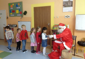 Mikołaj wręcza dzieciom upominki