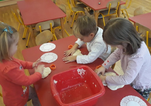 dzieci wykonują ozdowy choinkowe z masy solnej