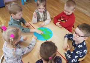dzieci malują farbami planetę ziemia