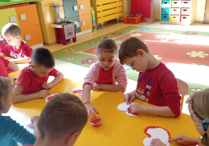 dzieci malują farbą szablon jabłka