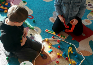 Gra „Gąsienica”. Dzieci ćwiczą szybkość ruchów ręki, prawidłowe trzymanie łyżki przygotowując się do nauki pisania.