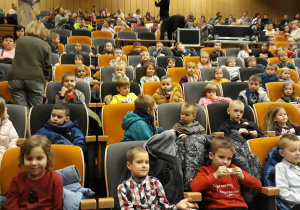 dzieci siedzą na widowni czekają na rozpoczęcie spektaklu