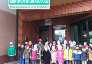 dzieci przed budynkiem gabinetu stomatologicznego