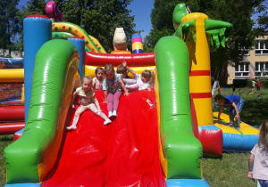 dzieci bawią się na dużej kolorowej zjeżdzalni