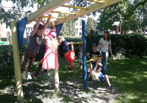 dzieci pokonują tor przeszkód w ogrodzie przedszkolnym, pokonują drabinkę
