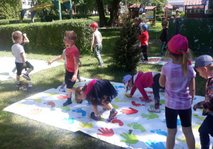 przedszkolaki bawią się w twista na trawie