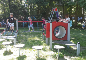 dzieci korzystają z urządzeń rekreacyjnych znajdujących się w ogrodzie przedszkolnym