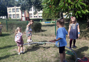 dzieci pokonuja tor przeszkód na przedszkolnym placu zabaw