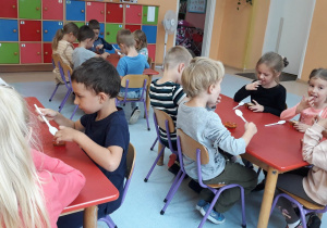 dzieci siedzą przy stolikach