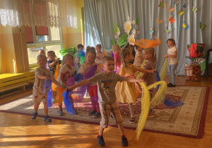 dzieci tańczą trzymając kolorowe chusteczki
