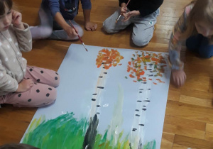 dzieci malują farbami jesienne drzewo